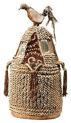 In Yorubaland, individuals venerate their ori-inu, representing an inner spirit guiding one's destiny. The ori-inu is symbolised by a small conical object placed within a larger container called ile-ori, meaning "house of the head." This shrine, made from leather and cloth adorned with cowrie shells and beads, serves as a homage to the ori-inu. The cowrie ornamentation signifies wealth, enhancing the prestige of the owner and emphasising the significance of this spiritual practice in Yoruba culture. The chicken atop is symbolic of the human's link with Oduduwa as a creative force.